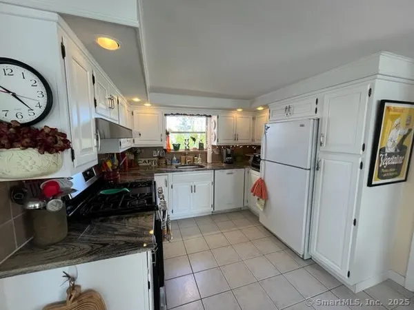 a kitchen with stainless steel appliances granite countertop a refrigerator and a sink