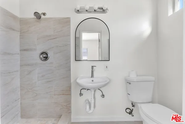 a bathroom with a sink a toilet and mirror