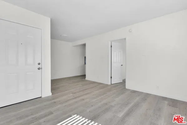 a view of an empty room with wooden floor