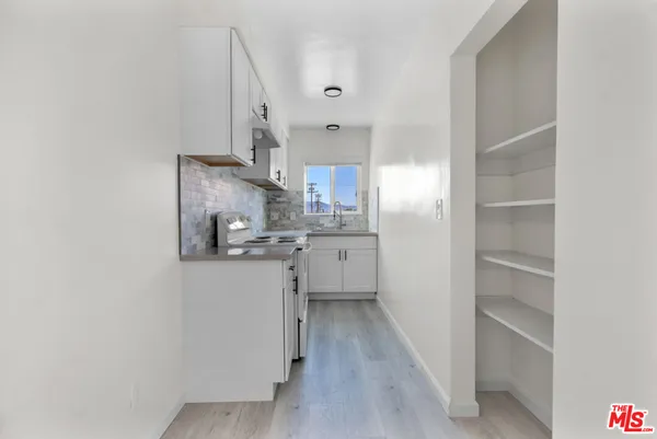 a kitchen with cabinets and wooden floor