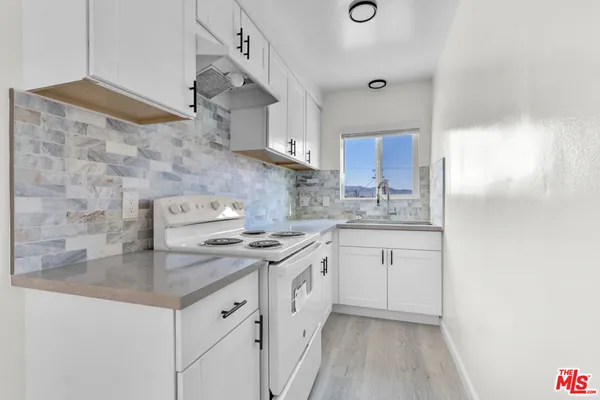 a kitchen with stainless steel appliances granite countertop a sink stove and cabinets