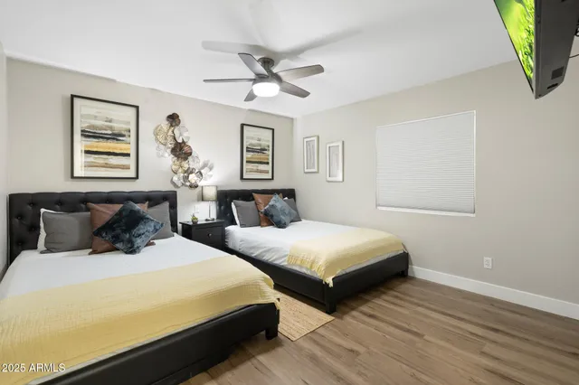 a bedroom with two beds and painting on the wall