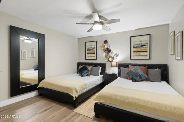 a bedroom with two large bed and a chandelier