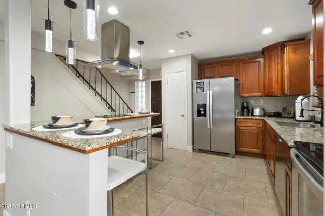 a kitchen with stainless steel appliances granite countertop a sink refrigerator and cabinets