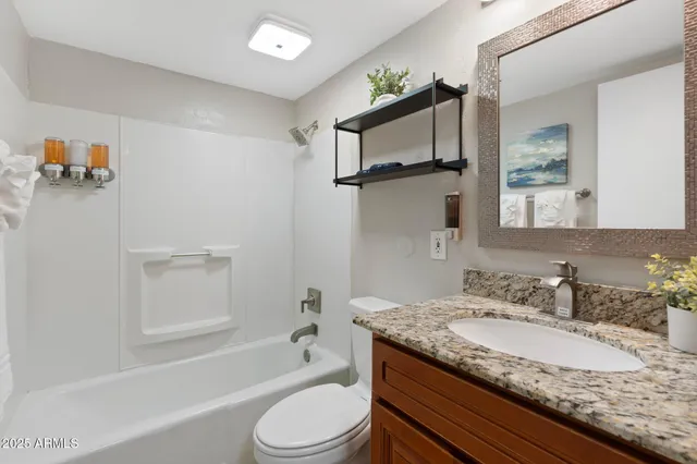 a bathroom with a granite countertop sink toilet and shower