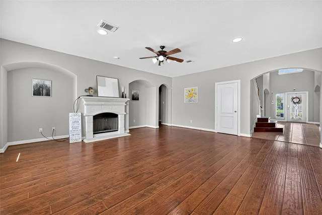 a view of empty room with wooden floor and fireplace