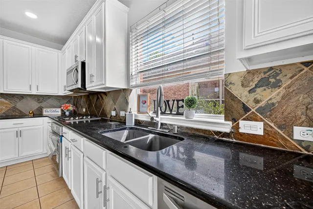 a kitchen with stainless steel appliances granite countertop a sink and a stove