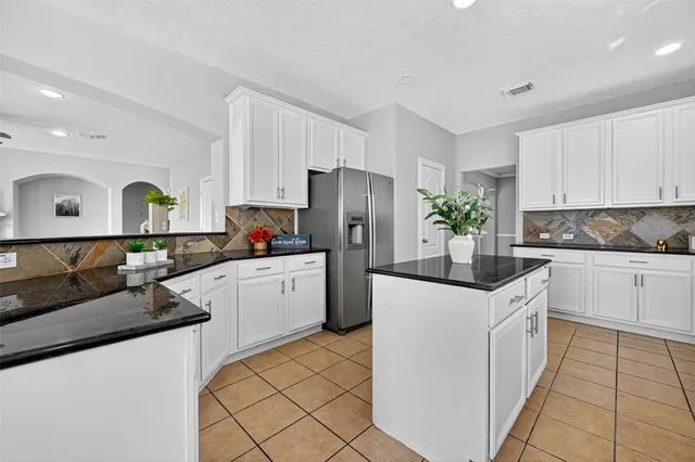 a kitchen with a sink a refrigerator and cabinets