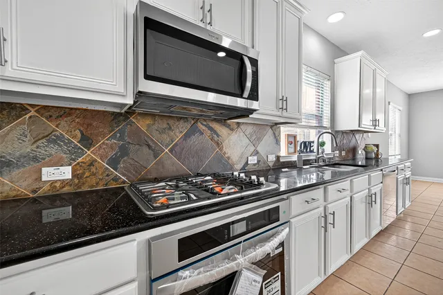 a kitchen with stainless steel appliances a stove and a microwave