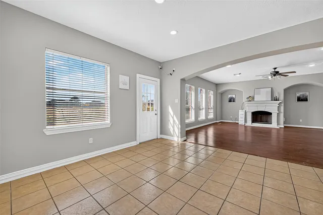 a view of empty room with fireplace and wooden floor