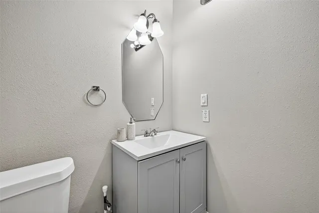 a bathroom with a toilet a sink and mirror