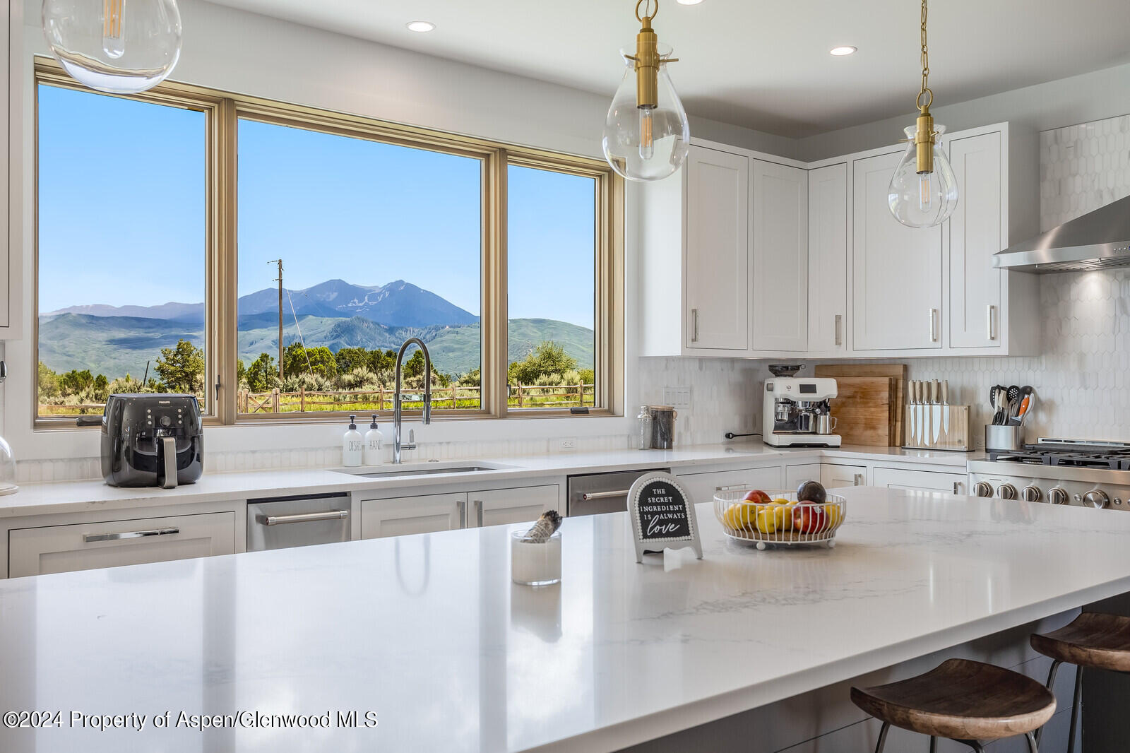 a kitchen with stainless steel appliances a sink a stove and a wooden floor