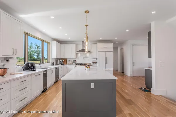 a large kitchen with kitchen island a sink stainless steel appliances and window