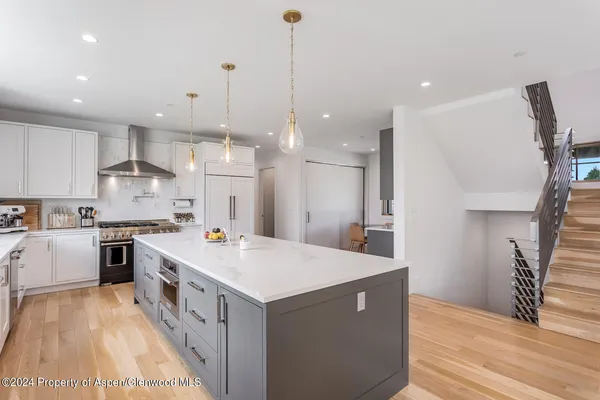 a view of a house next to a big yard with large trees
