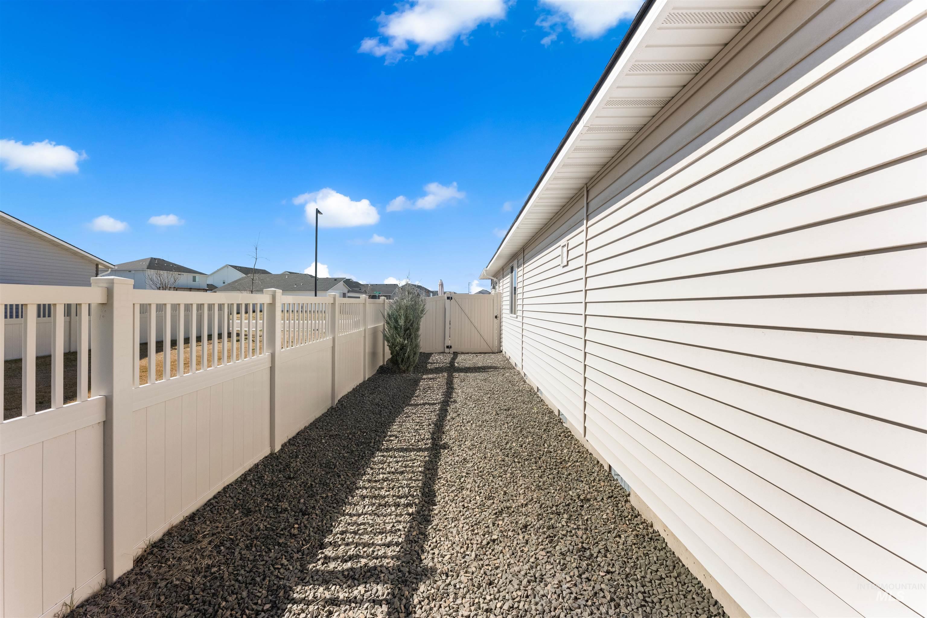 16378 Kelso Way Caldwell, ID 83607 - Photo 32 of 34 View of side of property featuring a gate, a fenced backyard, and a residential view