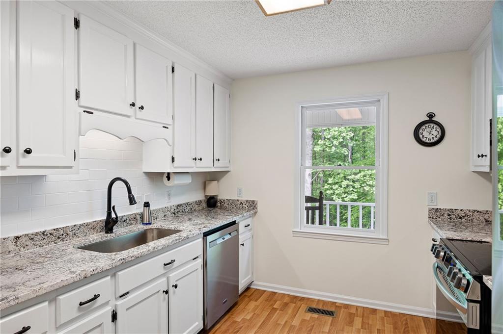 687 Cotton Road Canton, GA 30115 - Photo 14 of 38 a kitchen with granite countertop a sink and a stove