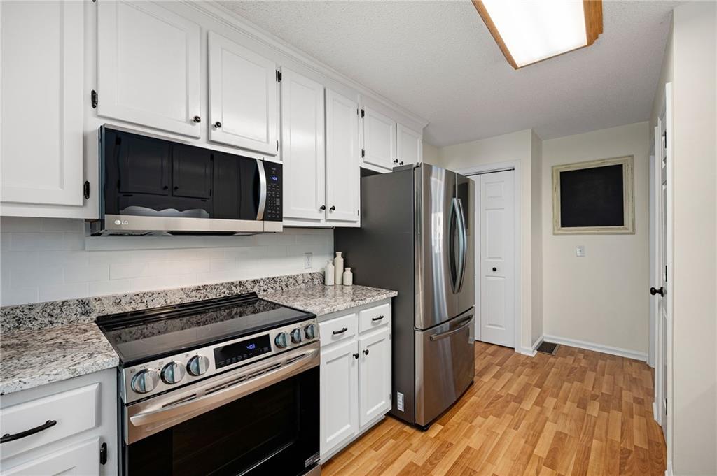 687 Cotton Road Canton, GA 30115 - Photo 16 of 38 a kitchen with stainless steel appliances a stove microwave and refrigerator