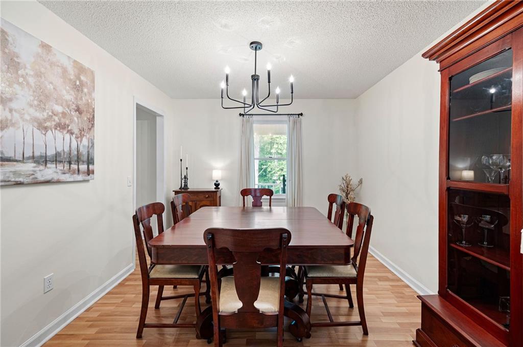 687 Cotton Road Canton, GA 30115 - Photo 18 of 38 a view of a dining room with furniture a chandelier and wooden floor
