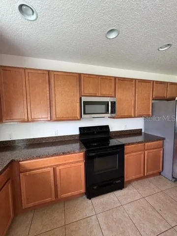 a kitchen with granite countertop cabinets and steel stainless steel appliances with a sink