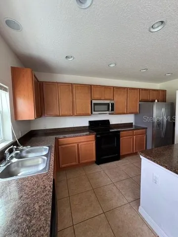 a kitchen with a sink a stove top oven and cabinets