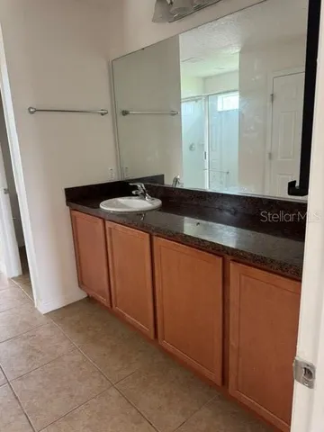 a bathroom with a granite countertop sink and a mirror