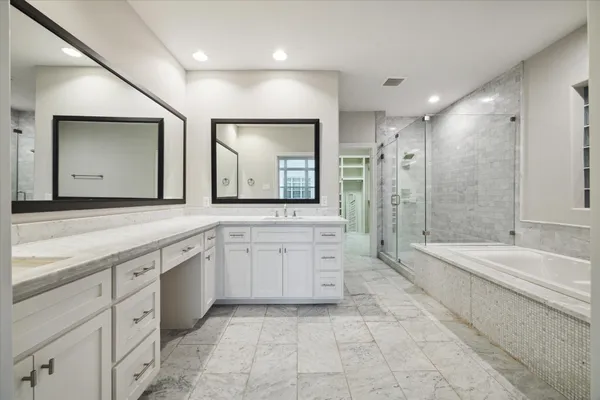 a spacious bathroom with a granite countertop tub sink shower and mirror