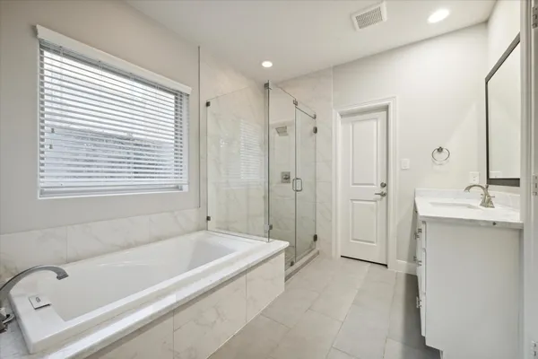 a spacious bathroom with a tub shower a sink and a mirror