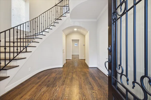 a view of a hallway with wooden floor and staircase
