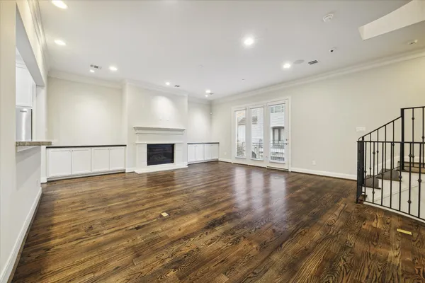 a view of empty room with wooden floor and fireplace