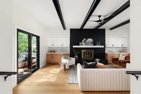 a living room with furniture a fireplace and a floor to ceiling window