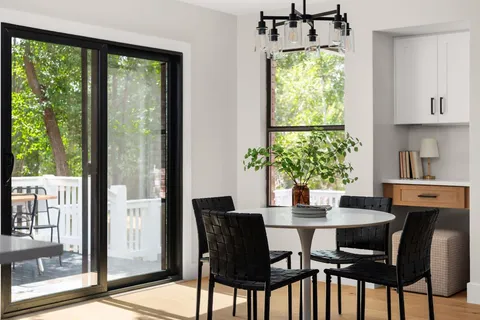 a dining room with furniture a window and a potted plant