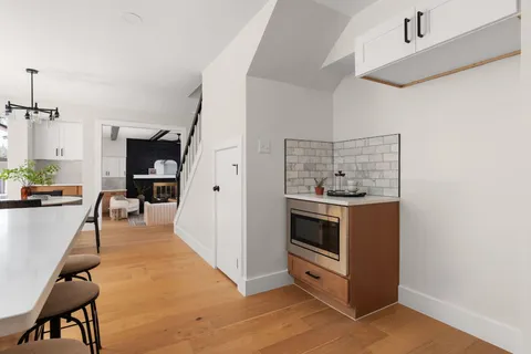 a kitchen with stainless steel appliances kitchen island hardwood floor and a sink