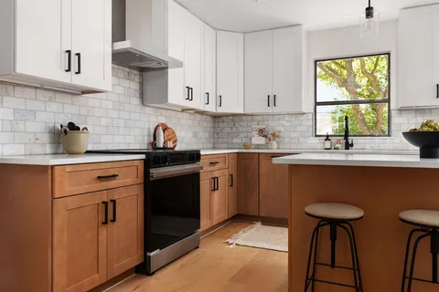 a kitchen with stainless steel appliances a sink stove and cabinets