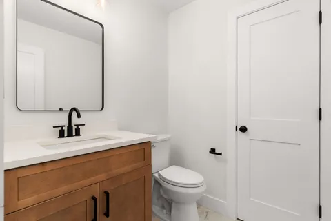 a bathroom with a sink a toilet and mirror