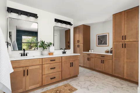 a spacious bathroom with double vanity sink a mirror and a bathtub