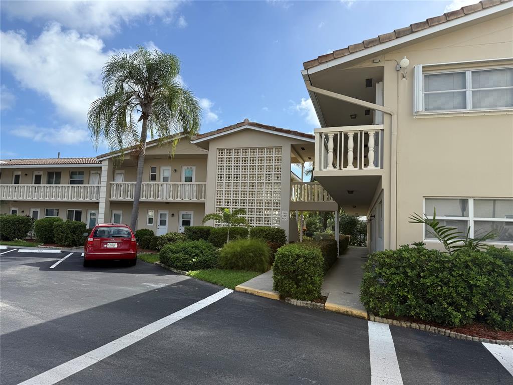 2131 Northeast 42nd Court, Unit 202E Lighthouse Point, FL 33064 - Photo 15 of 22 a front view of a house with a garden and plants