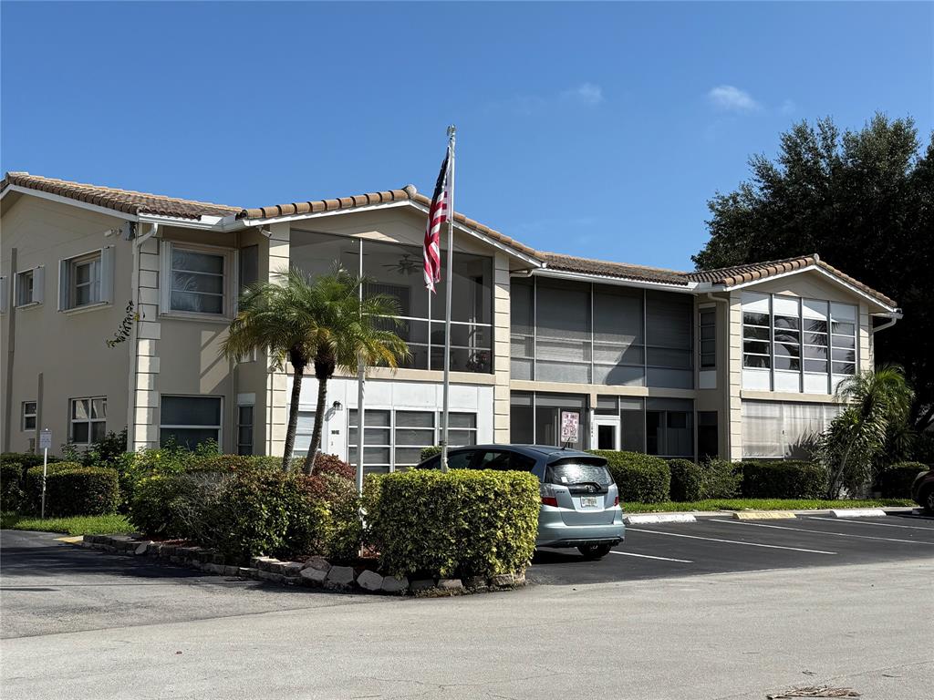 2131 Northeast 42nd Court, Unit 202E Lighthouse Point, FL 33064 - Photo 17 of 22 a car parked in front of a house
