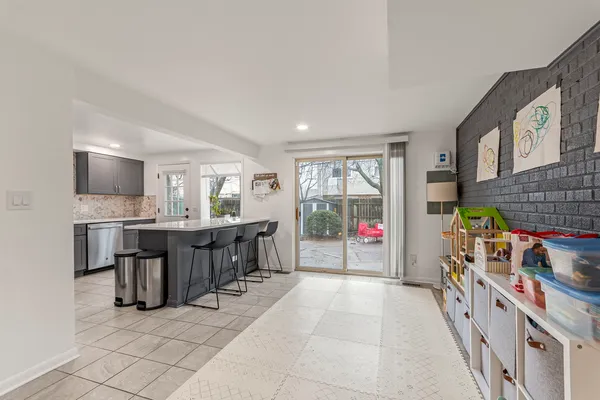 a room with lots of wooden furniture a chandelier and a view of kitchen