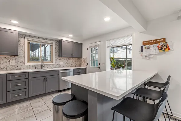 a large kitchen with kitchen island a dining table and chairs