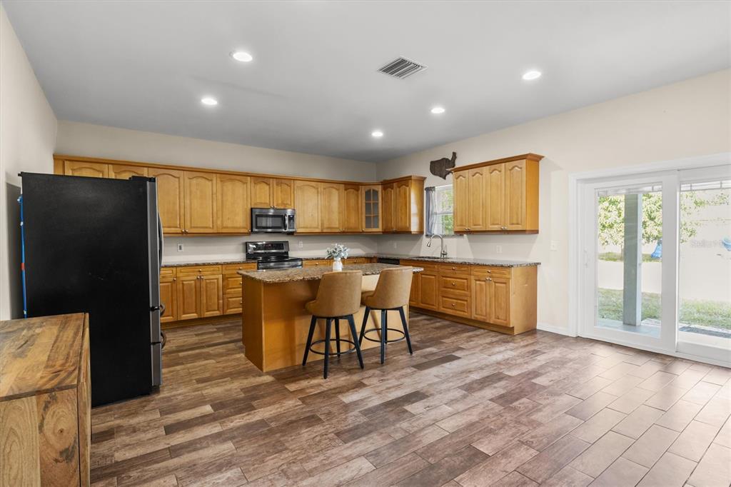 4020 Connersville Road Bartow, FL 33830 - Photo 11 of 50 a kitchen with stainless steel appliances granite countertop a refrigerator a stove top oven a sink and cabinets