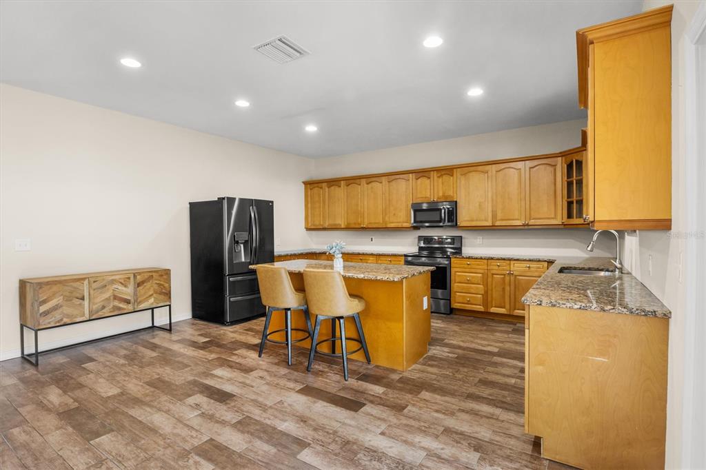4020 Connersville Road Bartow, FL 33830 - Photo 12 of 50 a kitchen with stainless steel appliances granite countertop a refrigerator a sink a stove and island