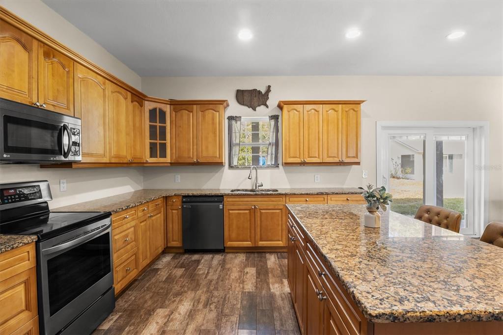 4020 Connersville Road Bartow, FL 33830 - Photo 13 of 50 a kitchen with stainless steel appliances granite countertop wooden cabinets a stove top oven a sink and dishwasher