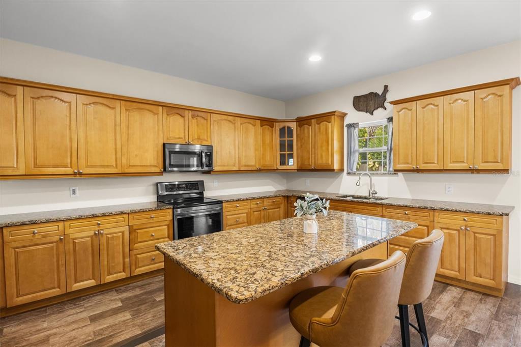 4020 Connersville Road Bartow, FL 33830 - Photo 14 of 50 a kitchen with stainless steel appliances granite countertop wooden cabinets a stove top oven a sink and dishwasher