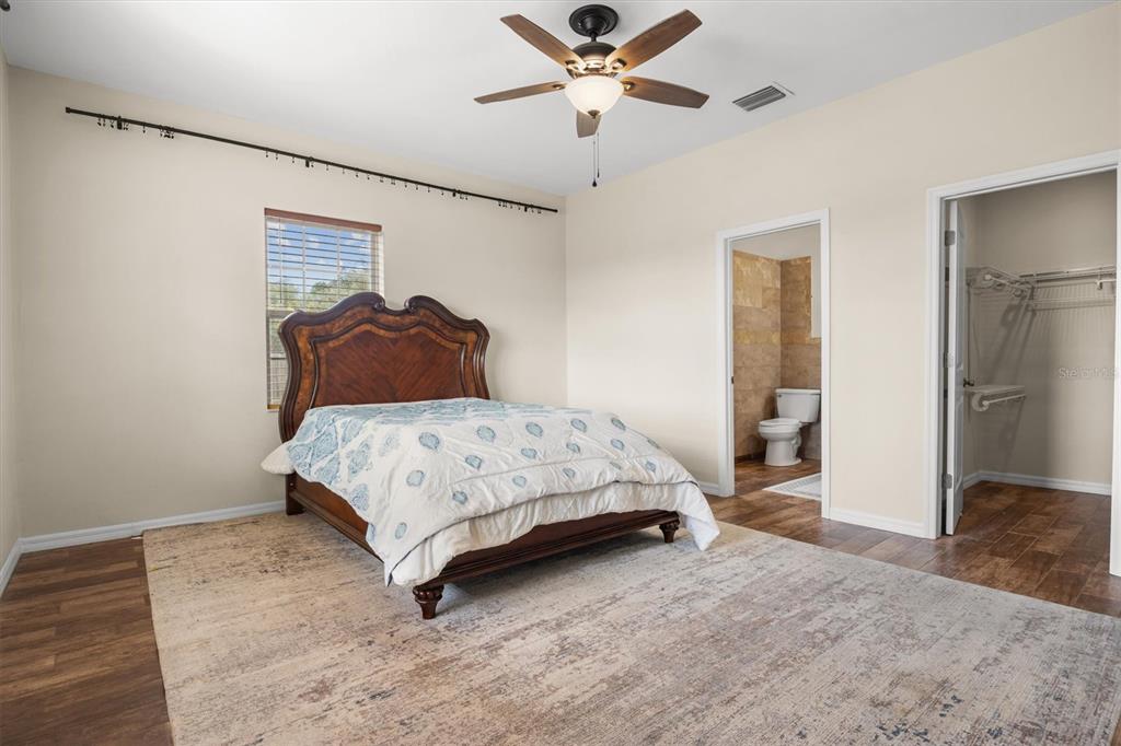 4020 Connersville Road Bartow, FL 33830 - Photo 25 of 50 a bedroom with a bed and a walk in closet with wooden floor