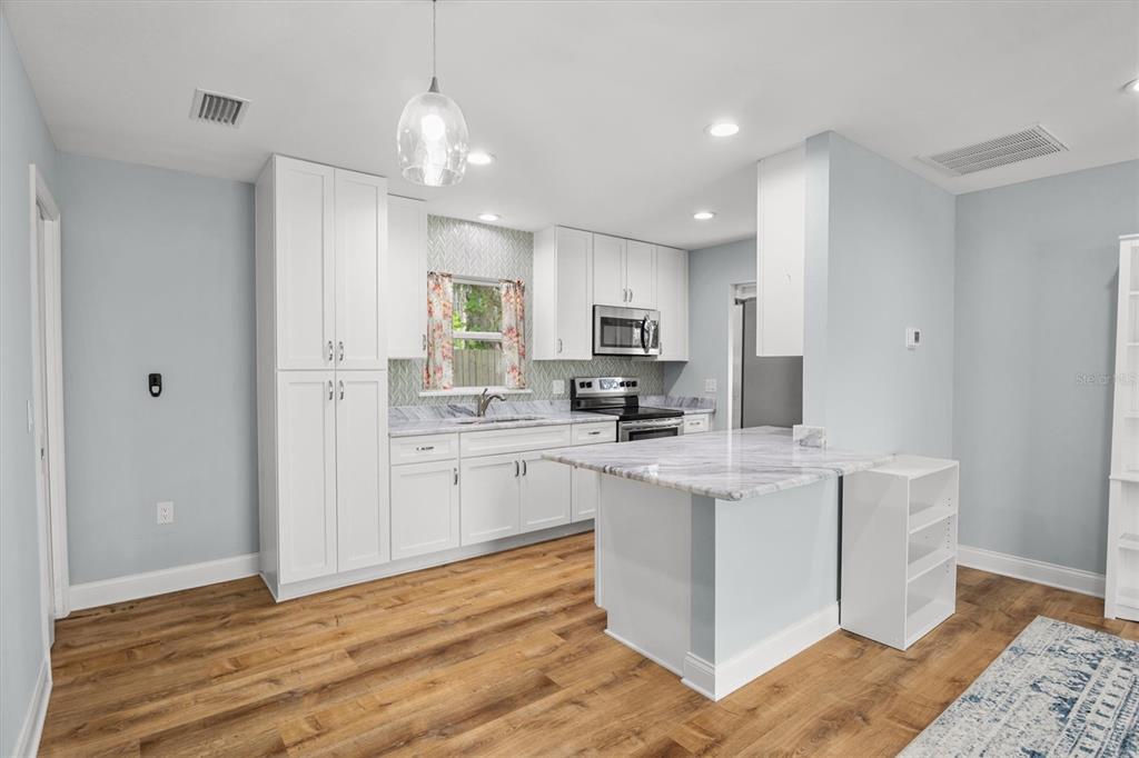 4020 Connersville Road Bartow, FL 33830 - Photo 41 of 50 a kitchen with stainless steel appliances kitchen island granite countertop a stove a sink and a refrigerator
