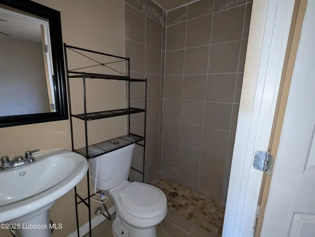a white toilet sitting next to a bathroom sink and a mirror