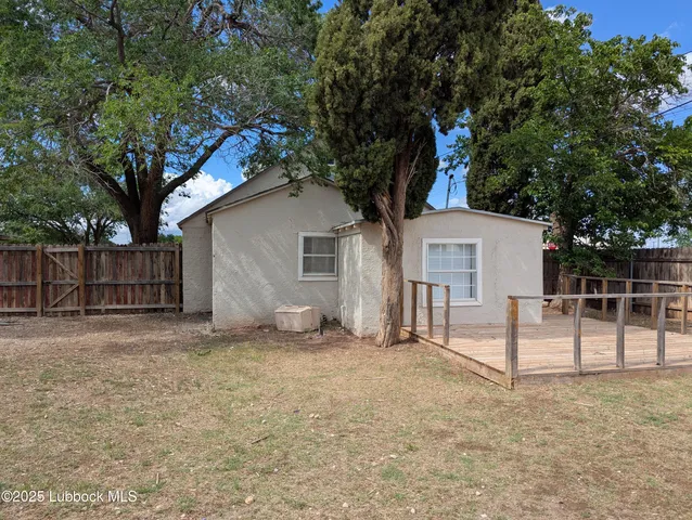 a view of a house with a small yard and a large tree