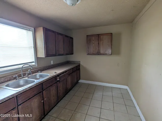 a kitchen with a sink a stove and cabinets
