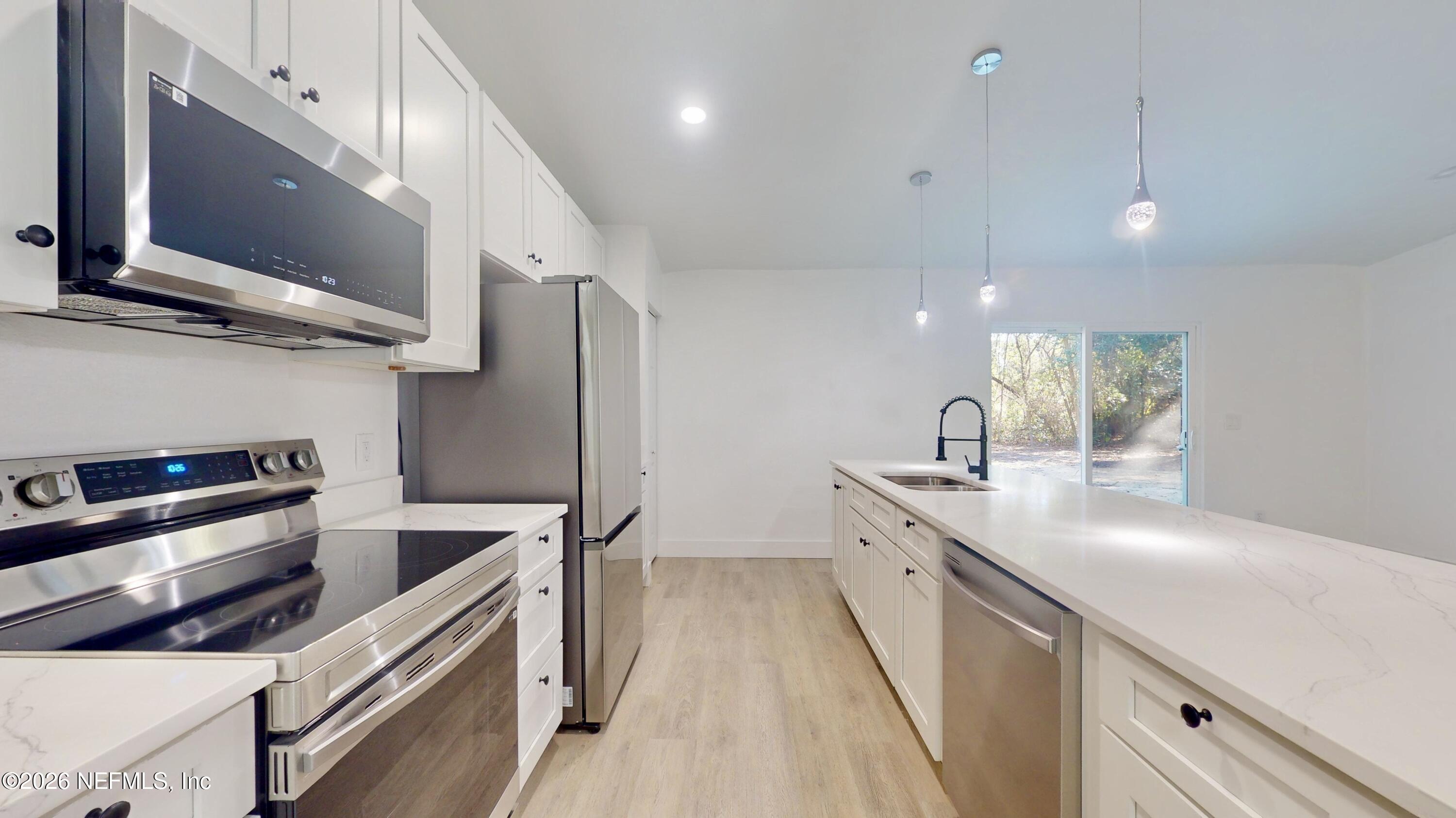 4774 Leopard Circle Middleburg, FL 32068 - Photo 19 of 50 a kitchen with stainless steel appliances a sink dishwasher a refrigerator and a microwave