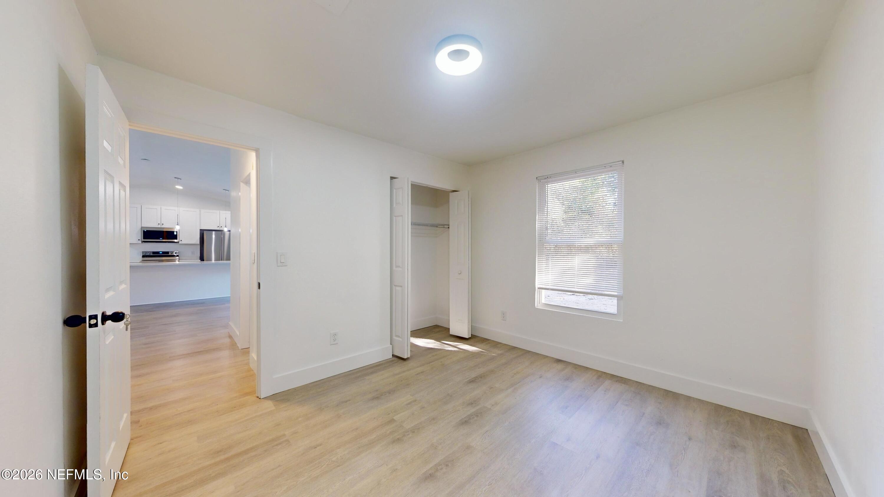 4774 Leopard Circle Middleburg, FL 32068 - Photo 32 of 50 an empty room with wooden floor and a window